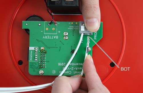 image shows pressing down on white terminals for solinst 107 tlc meter circuit board