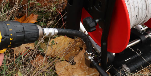 adaptateur solinst flex connecté à une perceuse sans fil qui entraîne le 101 enrouleur électrique pour élever et abaisser un compteur de niveau d'eau solinst