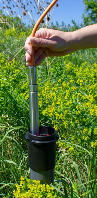 solinst levelvent vented water level datalogger being lowered into 2 inch locking well cap