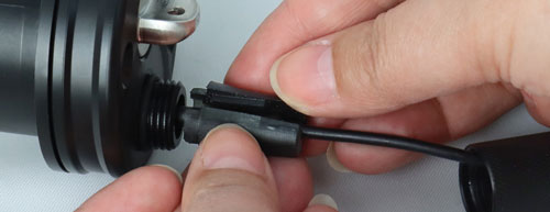 take the two pieces of the split grommet and put them on either side of the cable at the connection to the levelsender as shown