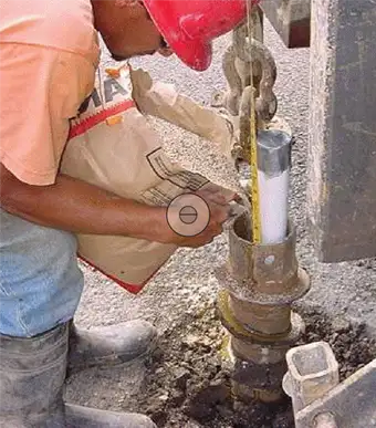 driller pouring bentonite in well on multilevel monitoring site