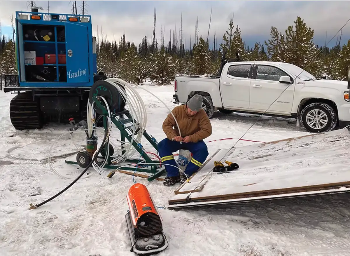 field technician preparing a Solinst Model 405 Water Flute multilevel groundwater monitoring system during cold weather site deployment